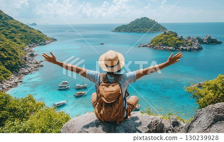 Backpacker with arms outstretched enjoys the turquoise ocean vie 130239928