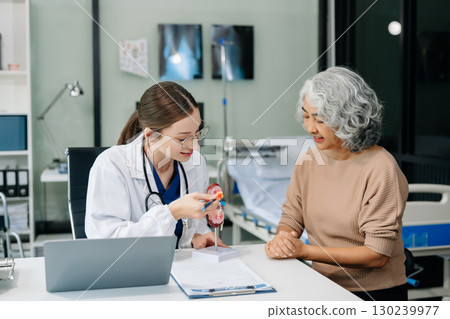 Doctor in white suit take notes while discussing and Asian elderly, man patient who lying on bed with receiving saline solution Doctor in white suit take notes while discussing and Asian elderly, man patient who lying on bed with receiving saline solution 130239977