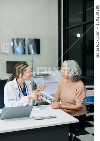 Doctor in white suit take notes while discussing and Asian elderly, man patient who lying on bed with receiving saline solution 130239980