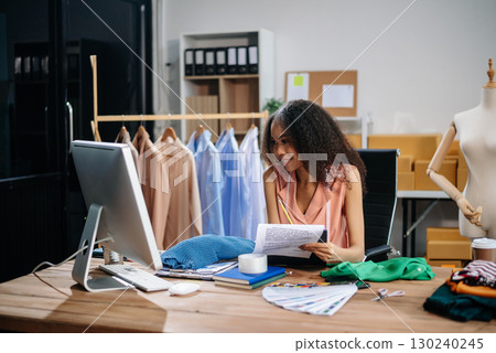 Successful fashion designer. Attractive young asian woman with smile while standing in workshop. Beautiful owner business woman working 130240245