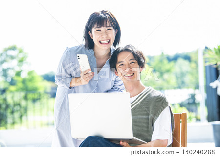 Couple portrait looking at camera smartphone computer 130240288