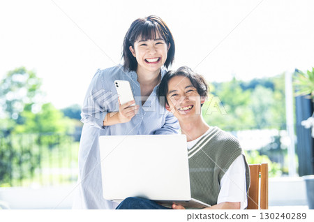 Couple portrait looking at camera smartphone computer 130240289