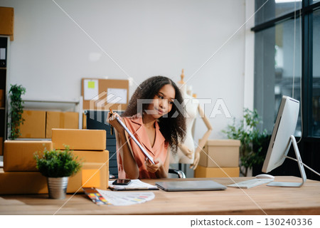Woman Entrepreneur: SME Business mastering e-commerce with tablet, laptop, packaging, with Online Marketing, Packaging, 130240336