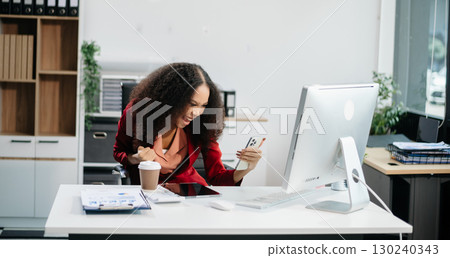Confident female entrepreneur looking at the camera while standing. Young businesswoman standing Confident female entrepreneur looking at the camera while standing. Young businesswoman standing 130240343