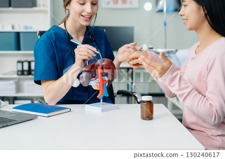 Doctor discussing treatment with Female patient talks to discuss results or symptoms and sitting on examination desk Doctor discussing treatment with Female patient talks to discuss results or symptoms and sitting on examination desk 130240617