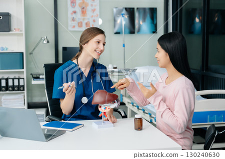 Doctor discussing treatment with Female patient talks to discuss results or symptoms and sitting on examination desk 130240630