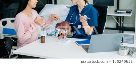 Doctor discussing treatment with Female patient talks to discuss results or symptoms and sitting on examination desk 130240631