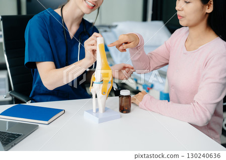Doctor discussing treatment with Female patient talks to discuss results or symptoms and sitting on examination desk 130240636