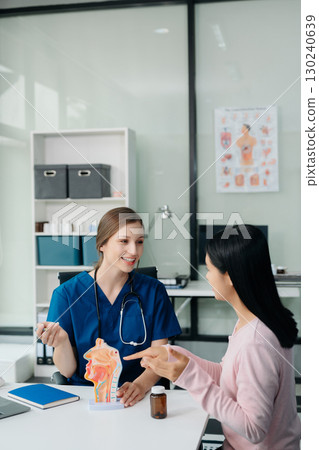 Doctor discussing treatment with Female patient talks to discuss results or symptoms and sitting on examination desk Doctor discussing treatment with Female patient talks to discuss results or symptoms and sitting on examination desk 130240639