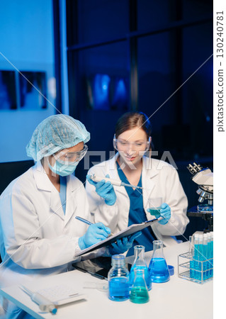 Modern Medical Research Laboratory Portrait of Two Scientists Working, Using Digital Tablet, Analyzing Samples, Talking. Modern Medical Research Laboratory Portrait of Two Scientists Working, Using Digital Tablet, Analyzing Samples, Talking. 130240781