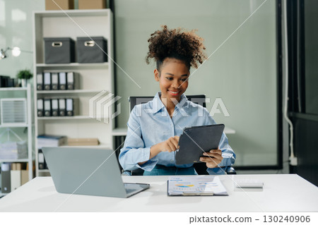 businesswoman working with working notepad, tablet and laptop documents talking on the smartphone, tablet 130240906