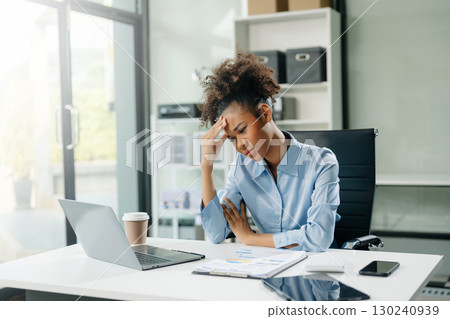 Woman feeling migraine head strain.Overworked businesswoman financier while working on laptop and tablet 130240939