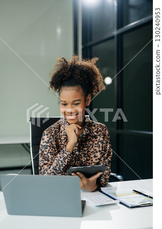 Confident business expert attractive smiling young woman typing laptop and holding digital tablet Confident business expert attractive smiling young woman typing laptop and holding digital tablet 130240953