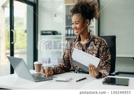 Confident business expert attractive smiling young woman typing laptop and holding digital tablet Confident business expert attractive smiling young woman typing laptop and holding digital tablet 130240955