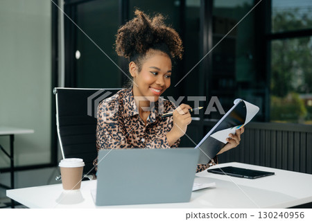 Confident business expert attractive smiling young woman typing laptop and holding digital tablet 130240956