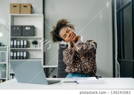 Overworked young Asian businesswoman office worker suffering from neck pain after had a long day 130241061
