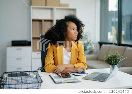 Confident woman with a smile standing holding notepad and tablet Confident woman with a smile standing holding notepad and tablet 130241443
