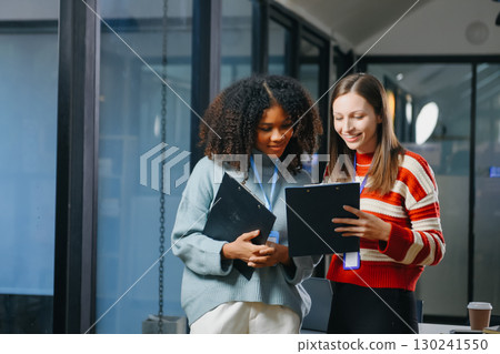 Two business workers talking on the smartphone and using laptop 130241550