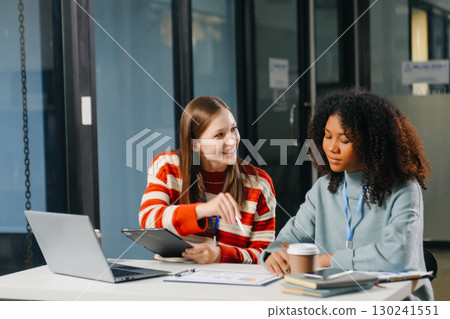 Two business workers talking on the smartphone and using laptop 130241551