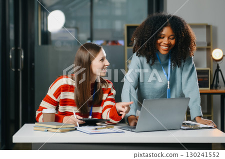 Two business workers talking on the smartphone and using laptop 130241552