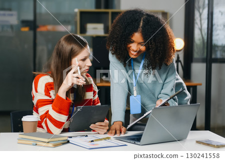 Two business workers talking on the smartphone and using laptop Two business workers talking on the smartphone and using laptop 130241558