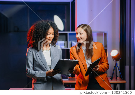 Two business workers talking on the smartphone and using laptop 130241560