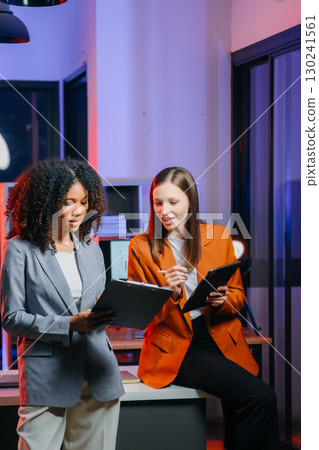 Two business workers talking on the smartphone and using laptop 130241561