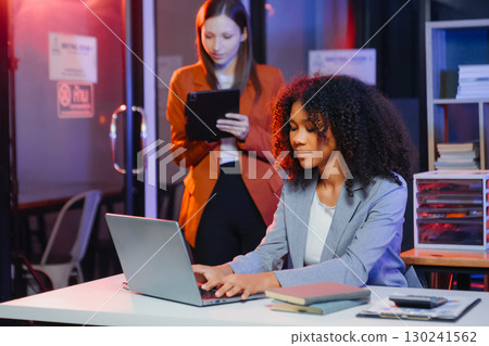 Two business workers talking on the smartphone and using laptop 130241562