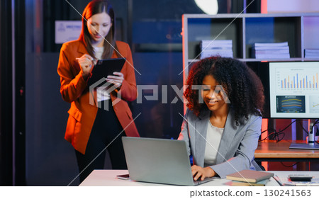 Two business workers talking on the smartphone and using laptop 130241563