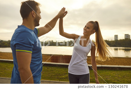 Sporty couple in sportswear giving high five each other rejoicing the success in sport training 130241678