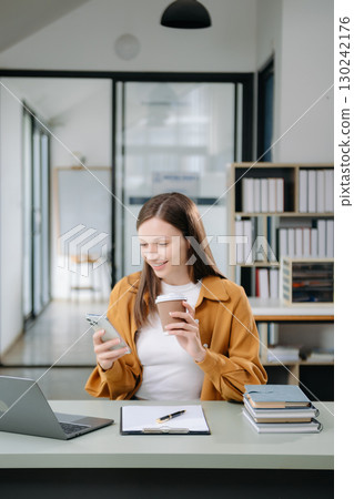 Confident woman with a smile standing holding notepad and tablet at the office. Confident woman with a smile standing holding notepad and tablet at the office. 130242176