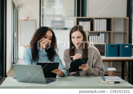 Asian business colleague business presents and explains and using laptop and tablet. Teamwork, financial marketing team Asian business colleague business presents and explains and using laptop and tablet. Teamwork, financial marketing team 130242201