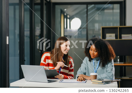 Two business workers talking on the smartphone and using laptop Two business workers talking on the smartphone and using laptop 130242265