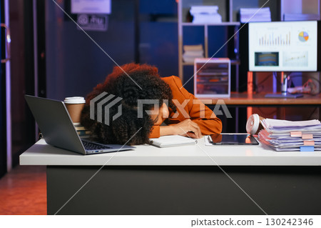 Woman feeling migraine head strain.Overworked businesswoman financier while working on laptop and tablet 130242346