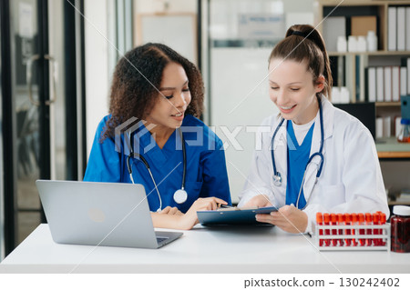 Doctor Talks With Professional Head Nurse or Surgeon, They Use Digital tablet Computer. Diverse Team of Health Care Specialists Discussing Test Result 130242402