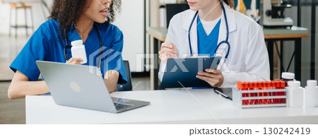 Modern Medical Research Laboratory Portrait of Two African American Scientists Working, Using Digital Tablet, Analyzing Samples, Talking. Modern Medical Research Laboratory Portrait of Two African American Scientists Working, Using Digital Tablet, Analyzing Samples, Talking. 130242419