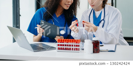 Modern Medical Research Laboratory Portrait of Two African American Scientists Working, Using Digital Tablet, Analyzing Samples, Talking. 130242424