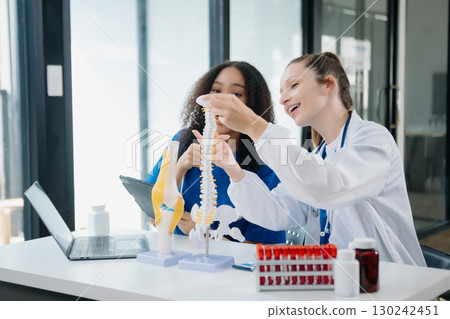 Doctor Talks With Professional Head Nurse or Surgeon, They Use Digital tablet Computer. Diverse Team of Health Care Specialists Discussing Test Result 130242451