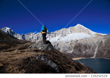Backpacking woman hiking on high altitude mountain top Backpacking woman hiking on high altitude mountain top 130242529
