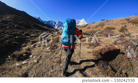 Backpacking woman hiking on high altitude mountain top 130242550