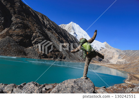 Backpacking woman hiking on high altitude mountain top 130242551