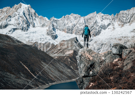 Backpacking woman hiking on high altitude mountain top Backpacking woman hiking on high altitude mountain top 130242567