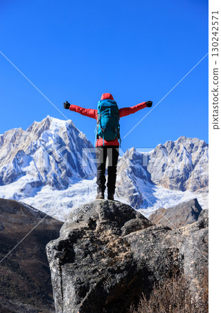 Backpacking woman hiking on high altitude mountain top 130242571