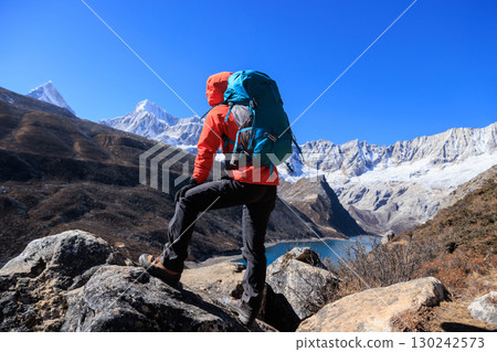Backpacking woman checking the elevation on sports watch on high altitude mountain top 130242573