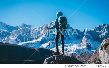 Backpacking woman hiking on high altitude mountain top Backpacking woman hiking on high altitude mountain top 130242577