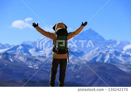 Successful woman hiker open arms to Mount Everest in Tibet, China Successful woman hiker open arms to Mount Everest in Tibet, China 130242578
