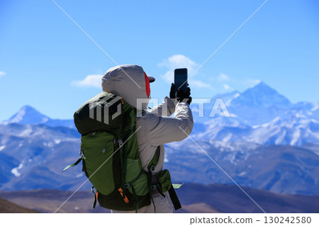 Successful woman hiker hiking to Mount Everest in Tibet, China Successful woman hiker hiking to Mount Everest in Tibet, China 130242580