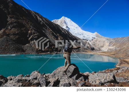 Backpacking woman hiking on high altitude mountain top 130243096