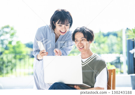 A couple searching on a computer and smartphone 130243188