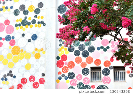 A building with polka dot walls and red crape myrtle flowers in Toranomon 130243298